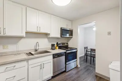 a kitchen with white cabinets and a sink and a stove at Scenic towers 3020 I Cozy & Comfy I Free Parking in Parma