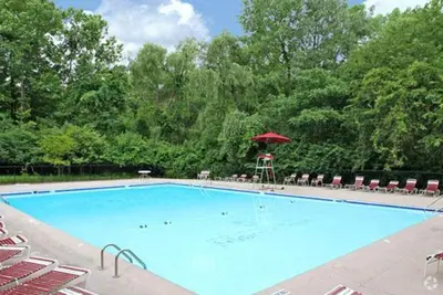 a large swimming pool with a red umbrella and chairs at Scenic towers 3105I Cozy & Comfy I Free Parking in Parma
