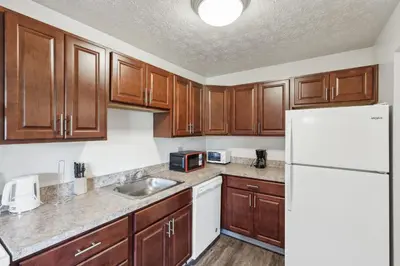 a kitchen with wooden cabinets and a white refrigerator at Scenic towers 3217I Cozy & Comfy I Free Parking in Parma