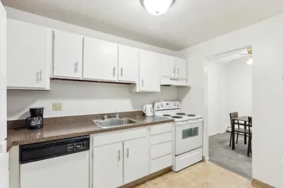 a kitchen with white cabinets and a sink and a stove at Midtown 3229I Cozy & Comfy I Free Parking in Parma