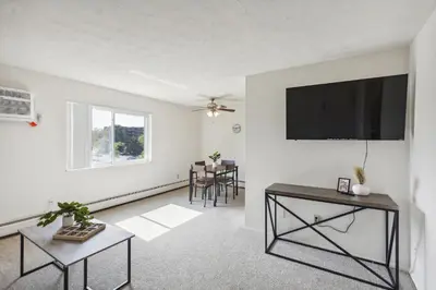a living room with a flat screen tv and a table at Midtown 3602I Cozy & Comfy I Free Parking in Parma