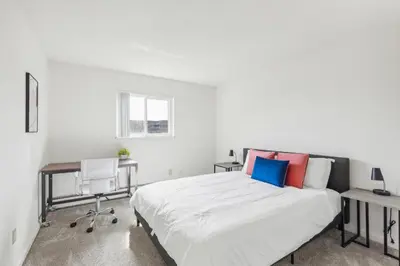 a white bedroom with a bed and a desk at Midtown 3603 I Cozy & Comfy I Free Parking in Parma