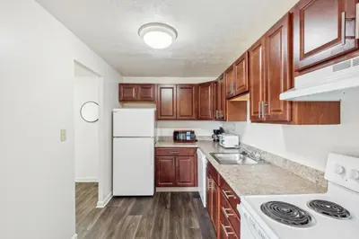 a kitchen with wooden cabinets and a white refrigerator at Midtown 3603 I Cozy & Comfy I Free Parking in Parma