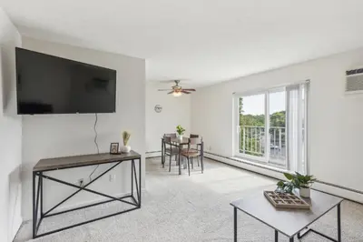 a living room with a flat screen tv and a table at Midtown 3603 I Cozy & Comfy I Free Parking in Parma