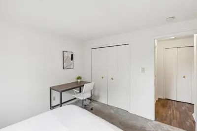 a white bedroom with a desk and a closet at Midtown 3605I Cozy & Comfy I Free Parking in Parma