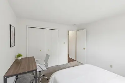 a bedroom with white walls and a desk and a bed at Midtown 3605I Cozy & Comfy I Free Parking in Parma