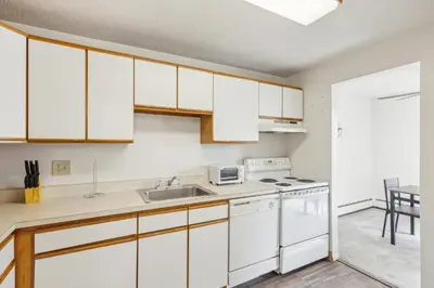 a kitchen with white cabinets and a sink at Midtown 3605I Cozy & Comfy I Free Parking in Parma