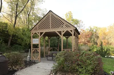 a wooden gazebo with a bench in a park at Midtown 3605I Cozy & Comfy I Free Parking in Parma