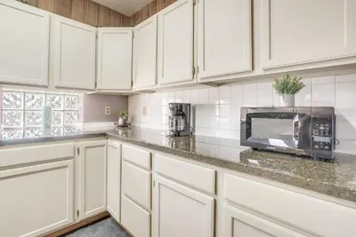a kitchen with white cabinets and a microwave at Downtown Condo about 23 Mi to Hocking Hills State Park in Lancaster