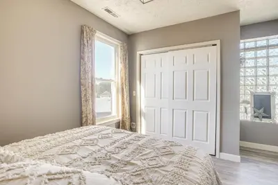 a bedroom with a white bed and a large window at Downtown Condo about 23 Mi to Hocking Hills State Park in Lancaster
