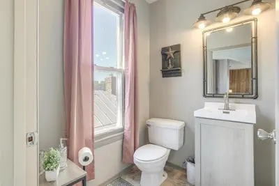 a bathroom with a toilet and a sink and a window at Downtown Condo about 23 Mi to Hocking Hills State Park in Lancaster