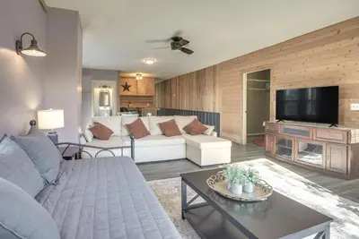 a living room with a white couch and a tv at Downtown Condo about 23 Mi to Hocking Hills State Park in Lancaster