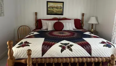 a bedroom with a bed with a quilt on it at Owl's Nest Retreat in Russellville