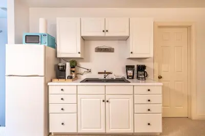 a kitchen with white cabinets and a white refrigerator at Owl's Nest Retreat in Russellville
