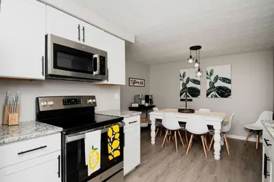 a kitchen and dining room with a table and a microwave at Modern Ranch near Downtown and Airport in Dayton