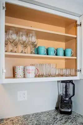 a cupboard with glasses and cups and a blender at Modern Ranch near Downtown and Airport in Dayton