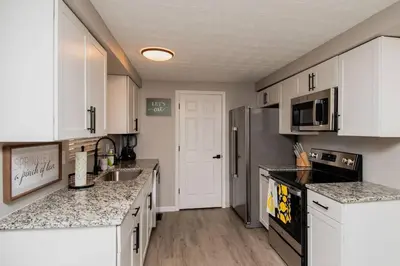 a kitchen with white cabinets and granite counter tops at Modern Ranch near Downtown and Airport in Dayton