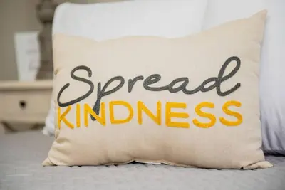 a pillow with the words spread kindness sits on a bed at Modern Ranch near Downtown and Airport in Dayton