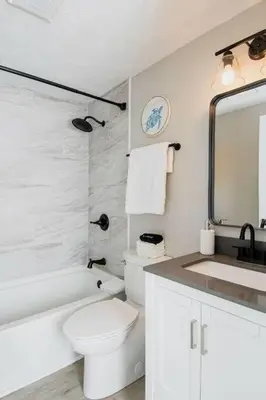 a white bathroom with a toilet and a sink at Modern Ranch near Downtown and Airport in Dayton