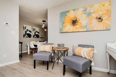 a living room with chairs and a painting on the wall at Modern Ranch near Downtown and Airport in Dayton
