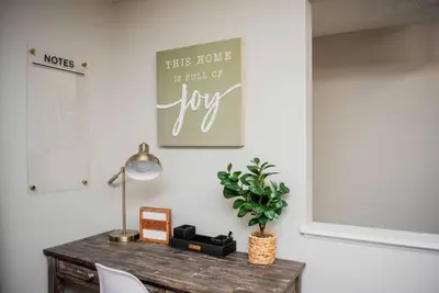 a desk with a lamp and a sign on a wall at Modern Ranch near Downtown and Airport in Dayton
