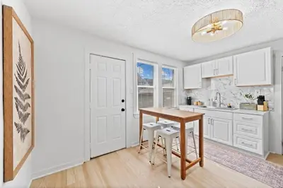 a kitchen with a wooden table and a table at Comfortable 2-Bedroom House In Cleveland 1330 in Cleveland