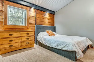 a bedroom with a bed and a dresser at Lake Escape with Hot Tub and Docks in Hope! in Hope
