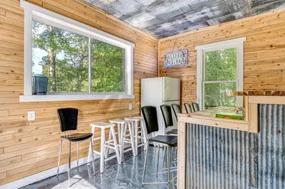 a kitchen with a bar with stools and a refrigerator at Lake Escape with Hot Tub and Docks in Hope! in Hope