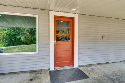 a red door on the side of a house at Lake Escape with Hot Tub and Docks in Hope! in Hope