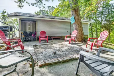 a group of red chairs sitting around a tree at Lake Escape with Hot Tub and Docks in Hope! in Hope