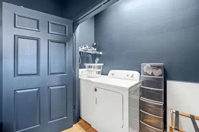 a laundry room with a washer and a blue wall at Top-Rated 1BR Near Convention Center & Parking in Covington