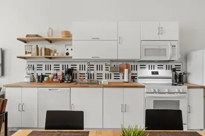 a kitchen with white cabinets and a white microwave at Top-Rated 1BR Near Convention Center & Parking in Covington