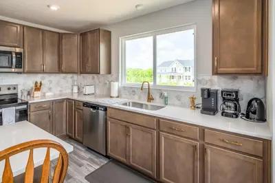 a kitchen with wooden cabinets and a window at Full Home by Ark and Creation Museum in Walton
