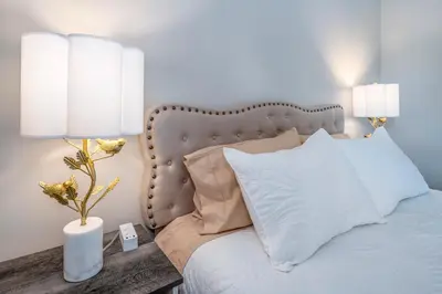 a bedroom with a bed with white pillows and two lamps at Full Home by Ark and Creation Museum in Walton