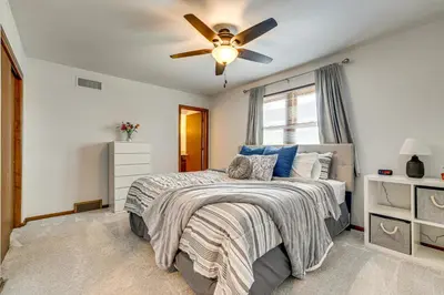 a bedroom with a bed with a ceiling fan at 11 Mi to Dtwn Columbus Group Retreat with Fire Pit! in Worthington