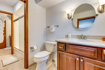 a bathroom with a toilet and a sink and a mirror at 11 Mi to Dtwn Columbus Group Retreat with Fire Pit! in Worthington