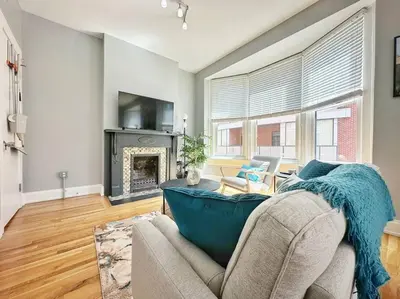 a living room with a couch and a fireplace at Boho Studio Loft Meets Luxury in OTR Cincinnati! in Cincinnati