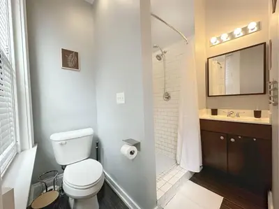 a white bathroom with a toilet and a sink at Boho Studio Loft Meets Luxury in OTR Cincinnati! in Cincinnati