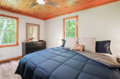 a bedroom with a large blue bed with a wooden ceiling at Game RoomHot Tub4mi to Rock HouseGives Back! in Laurelville