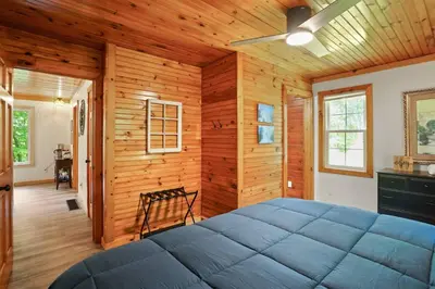 a bedroom with a large blue bed in a wooden wall at Game RoomHot Tub4mi to Rock HouseGives Back! in Laurelville