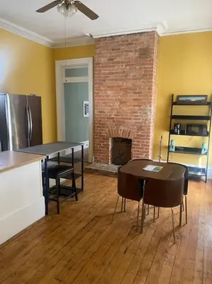 a living room with a table and a fireplace at Victorian Getaway in Cincinnati
