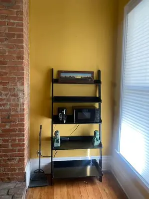 a black shelf with a microwave in a room at Victorian Getaway in Cincinnati