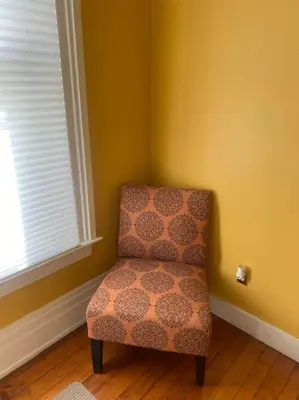 a chair sitting in a corner of a room at Victorian Getaway in Cincinnati