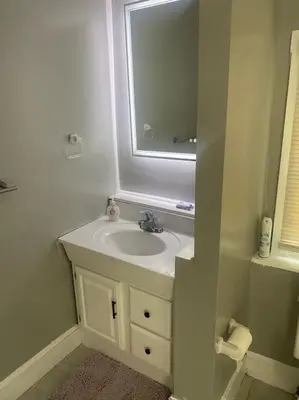 a white bathroom with a sink and a mirror at Victorian Getaway in Cincinnati