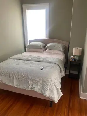 a bed in a bedroom with a window at Victorian Getaway in Cincinnati