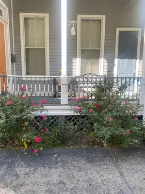a porch of a house with a bench and flowers at Victorian Getaway in Cincinnati