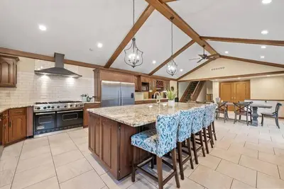 a large kitchen with a large island with bar stools at 12,700 sf 8 Room Mansion on 18 acres in Medina