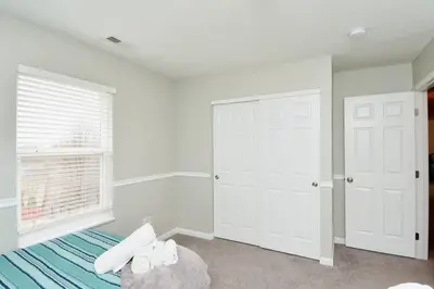 a bedroom with white walls and a bed and a window at Modern Retreat near downtown Dayton in Dayton