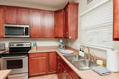 a kitchen with wooden cabinets and a sink at Modern Retreat near downtown Dayton in Dayton
