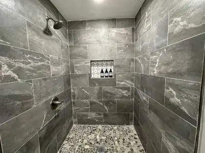 a bathroom with a shower with gray tiles at Modern Retreat - Newly Remodeled Gem in Englewood
